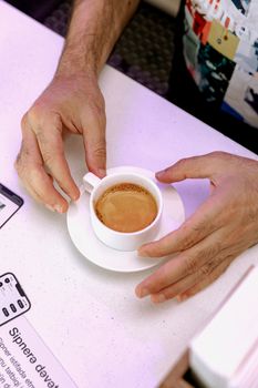 Barista presenting a freshly brewed espresso in a cup at a coffeehouse in Baku, Azerbaijan.