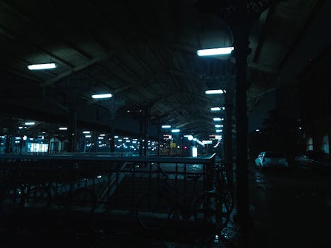 Cinematic view of a dark, moody railroad station at night in Gdańsk, Poland.