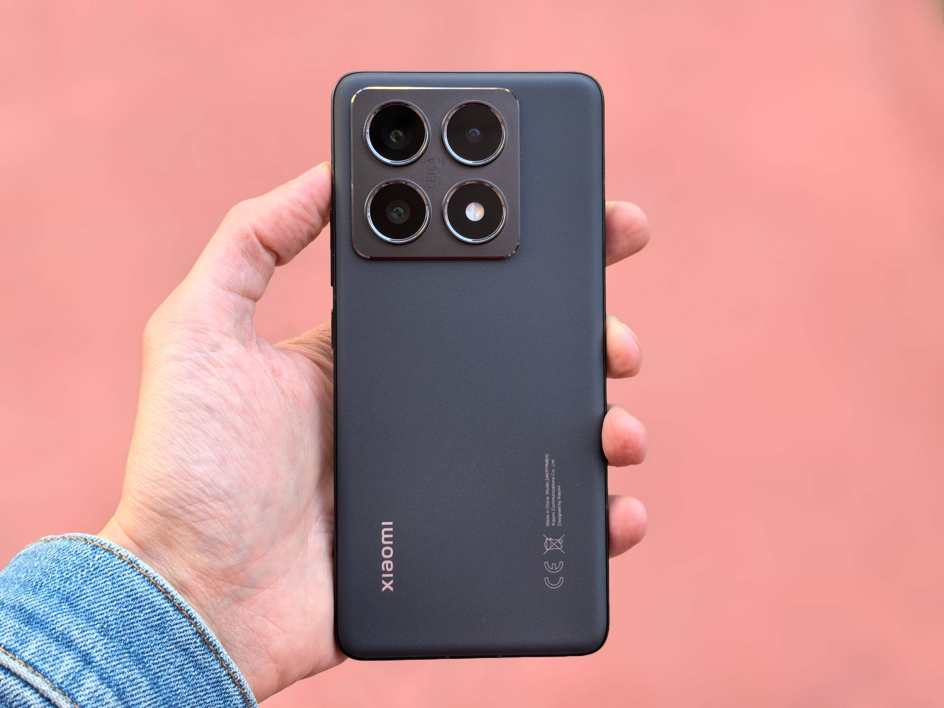 Close-up of a modern smartphone with a triple-lens camera held by a person.