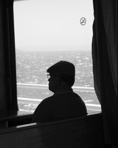 Free Silhouette of a man gazing out at the sea from a ferry window in Türkiye. Stock Photo