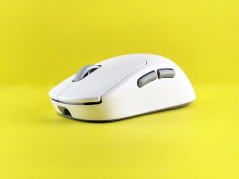 Modern white wireless mouse against a bright yellow backdrop, emphasizing technology and design.