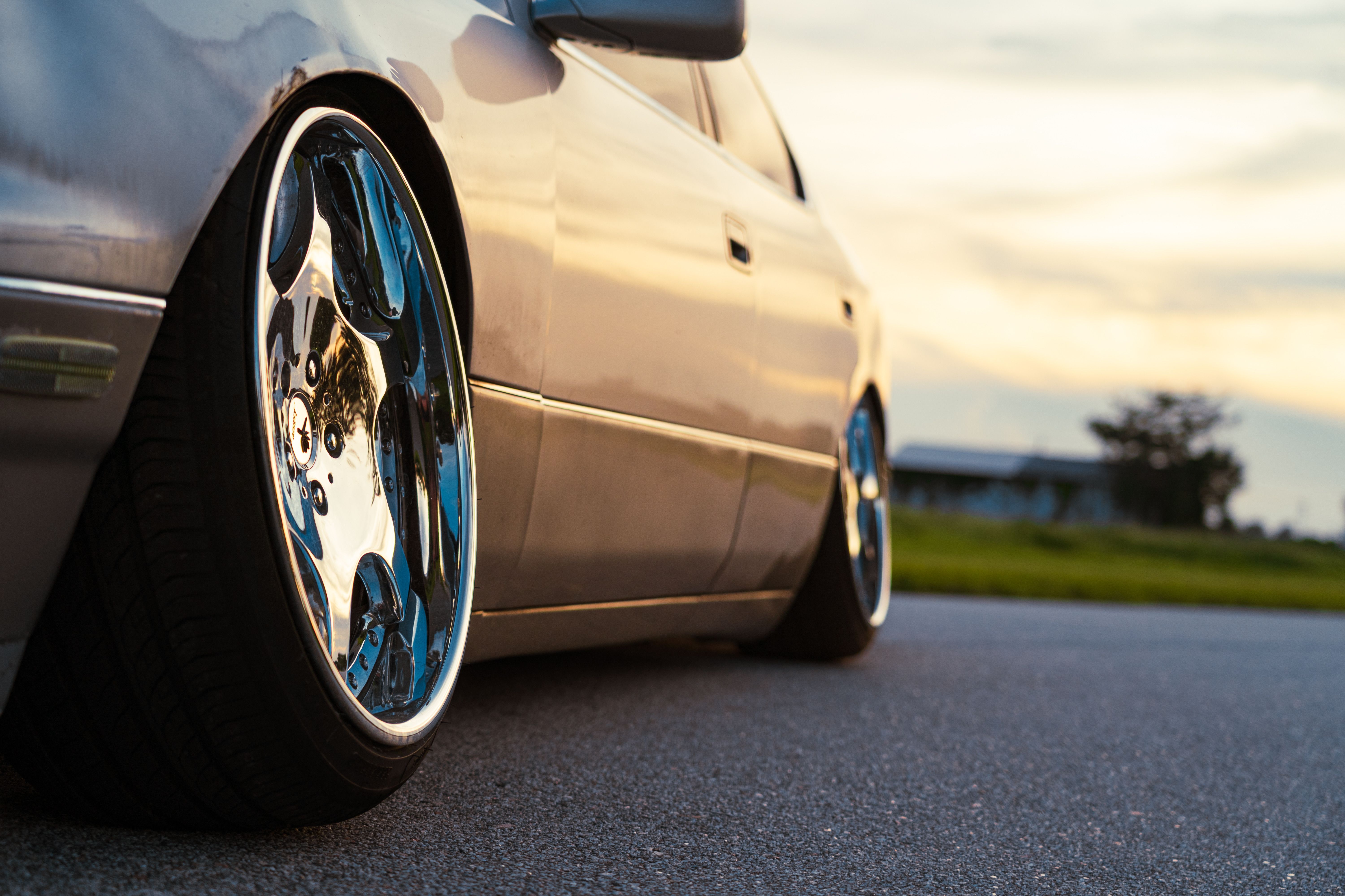 Close-Up of Car with Shiny Chrome Wheels at Sunset · Free Stock Photo