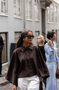 Stylish individuals walking on a street in Copenhagen, showcasing modern fashion.