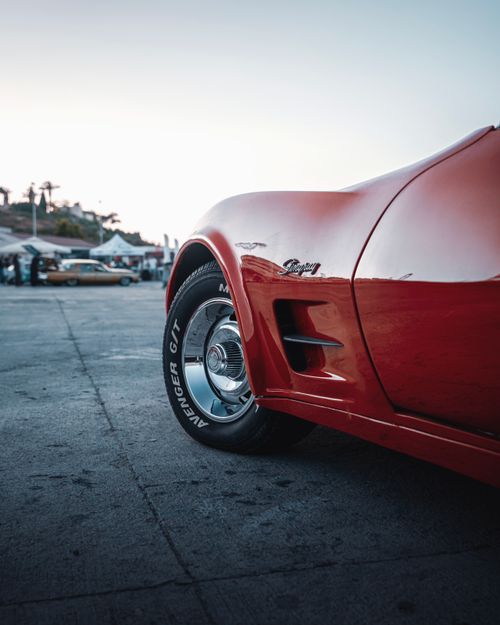 Free Close-up of a vintage red car at sunset in İzmir, highlighting its sleek design and nostalgic appeal. Stock Photo