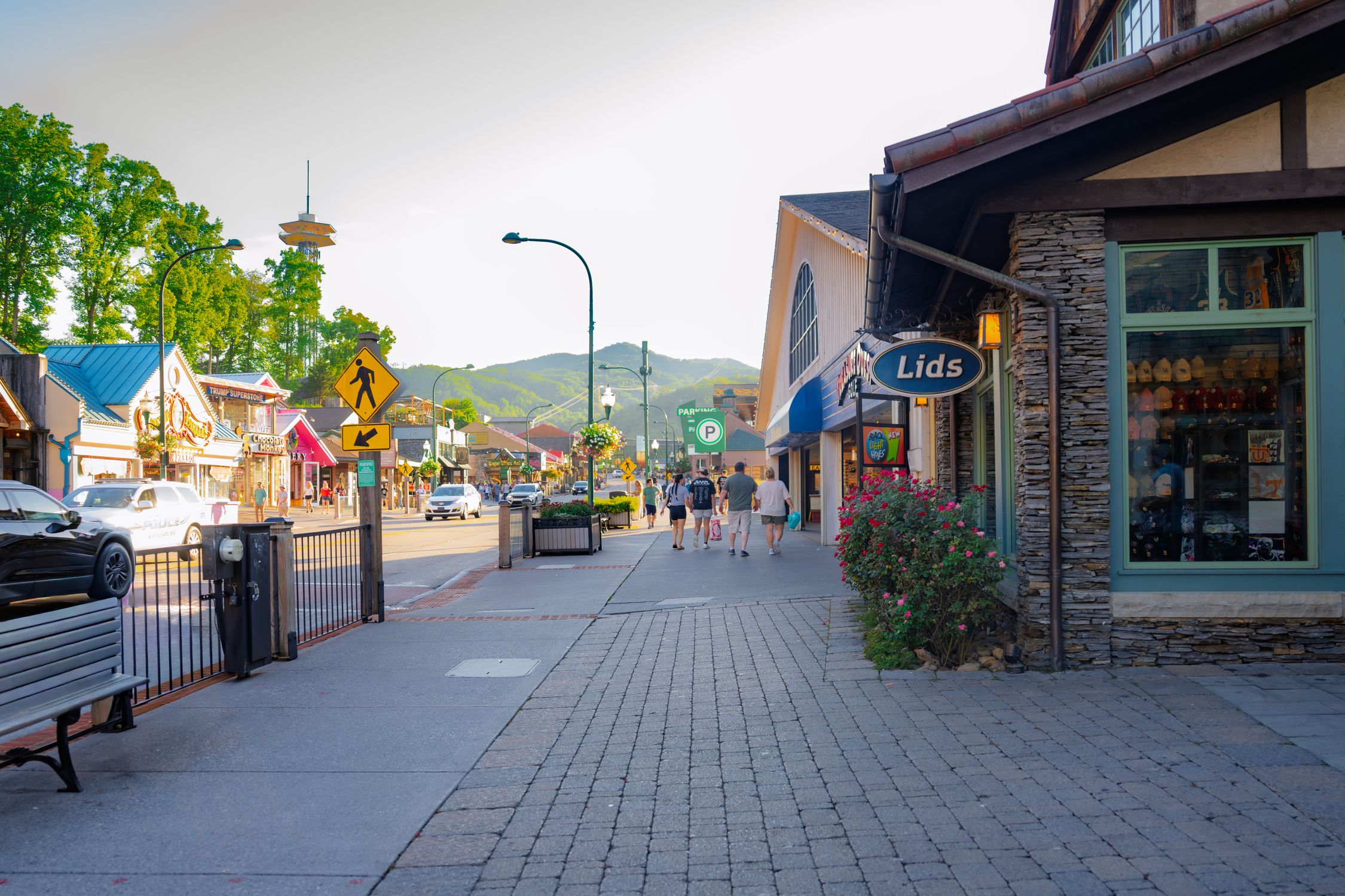 Quaint street scene in Gatlinburg, Tennessee with shops and distant mountains.