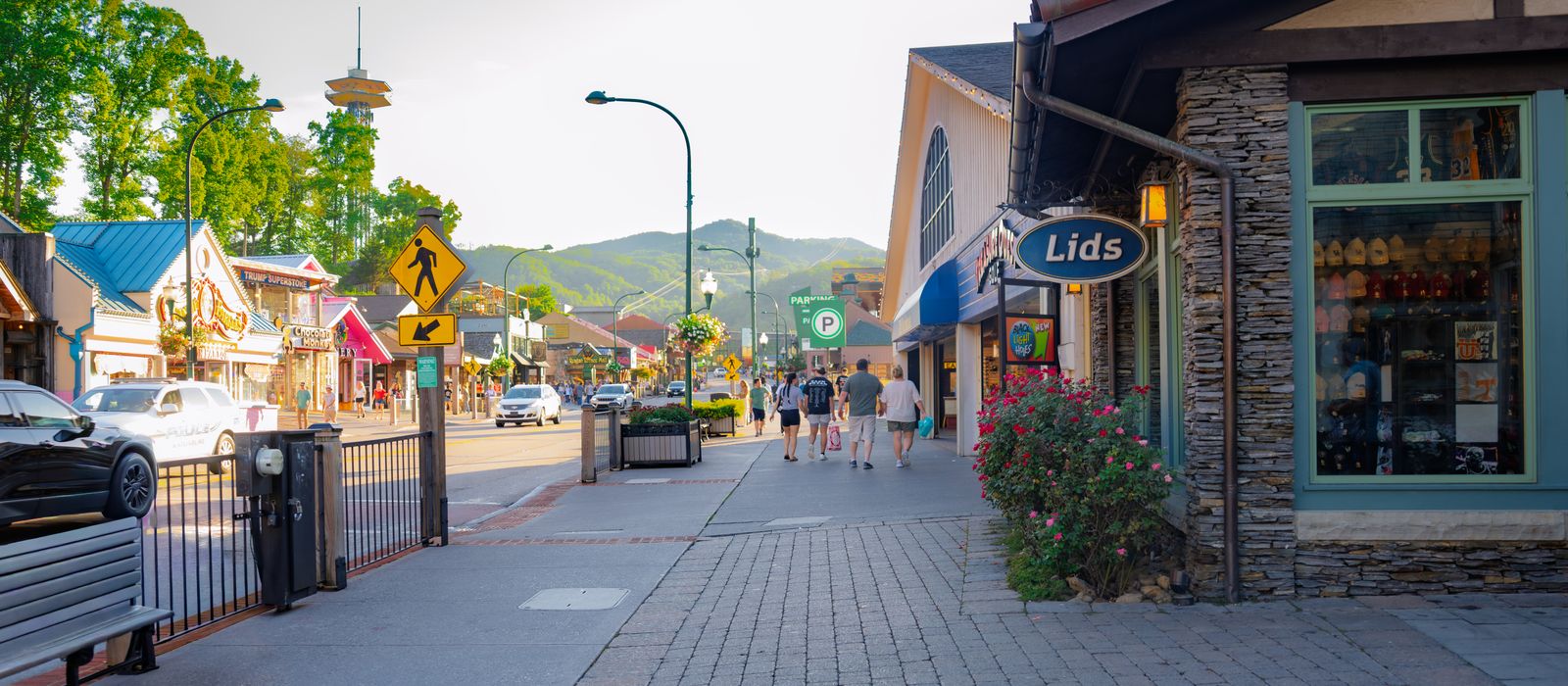 Quaint street scene in Gatlinburg, Tennessee with shops and distant mountains.