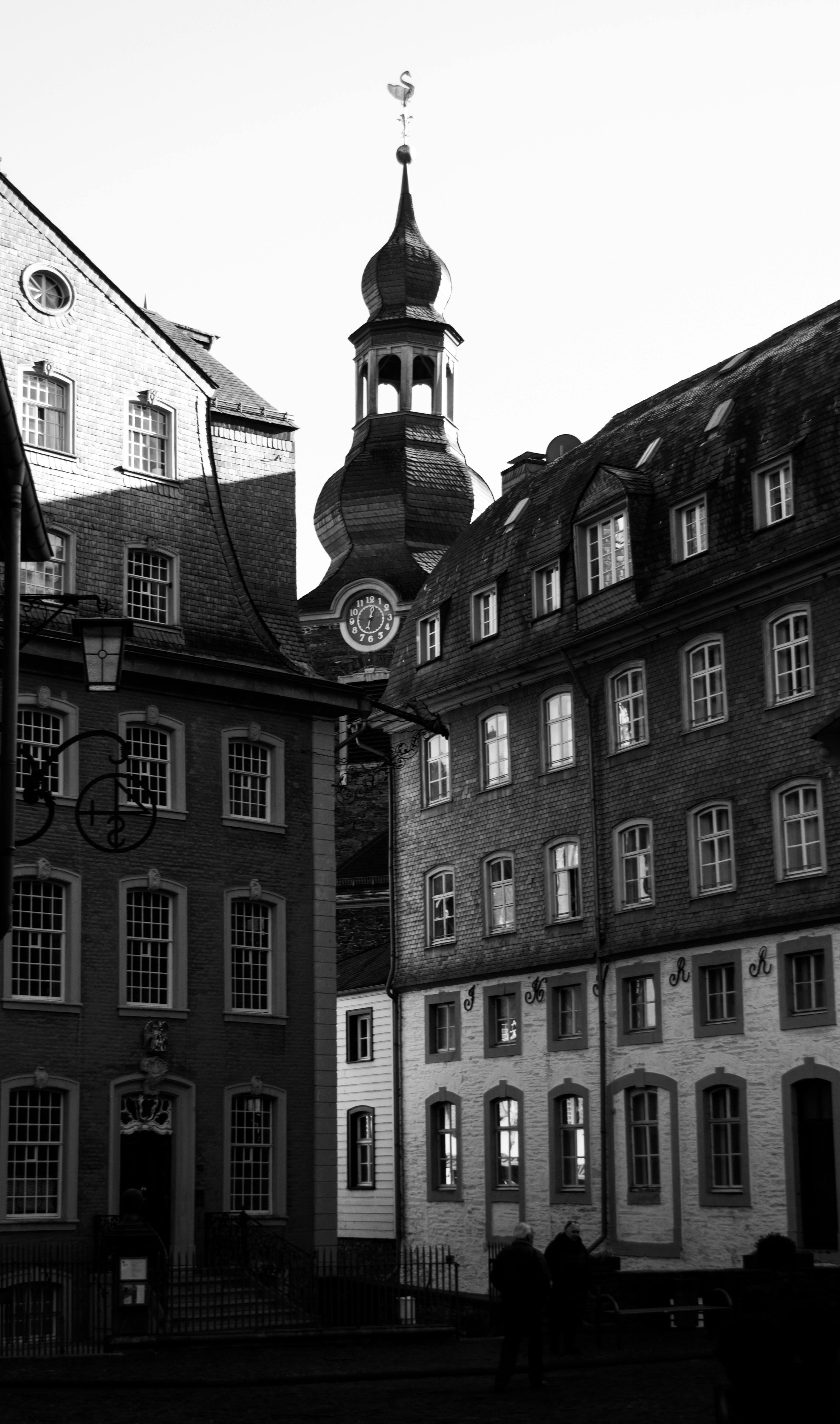 Black and white photo of historic European buildings and a prominent church steeple.