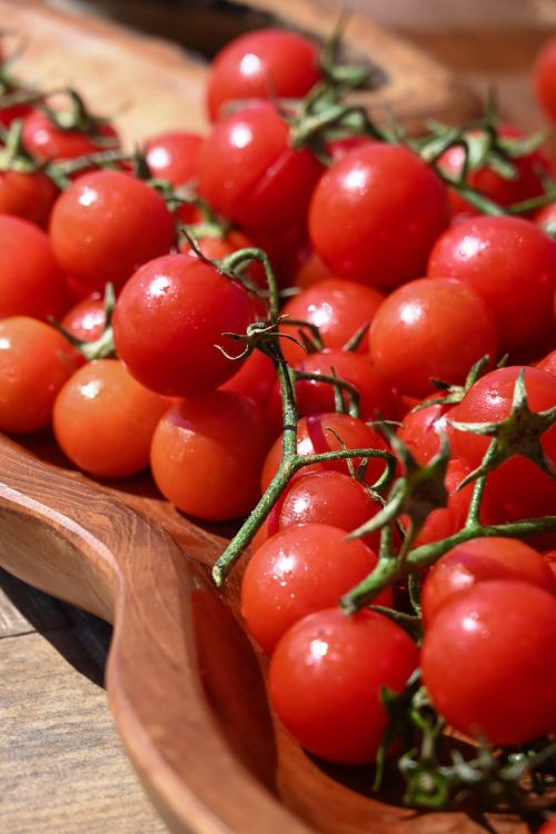 Free Vibrant cherry tomatoes in a rustic wooden bowl, perfect for salads and healthy cooking. Stock Photo