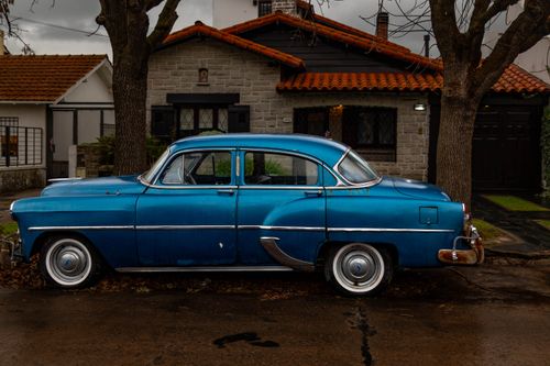 Free Vintage blue car parked on a rainy street in Mar del Plata, Argentina, showcasing classic automobile design. Stock Photo
