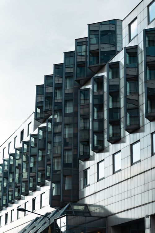 Free A striking view of modern building architecture with geometric glass windows. Stock Photo