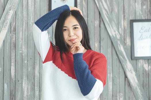 一个女人穿着彩色针织毛衣，在木制背景下摆姿势