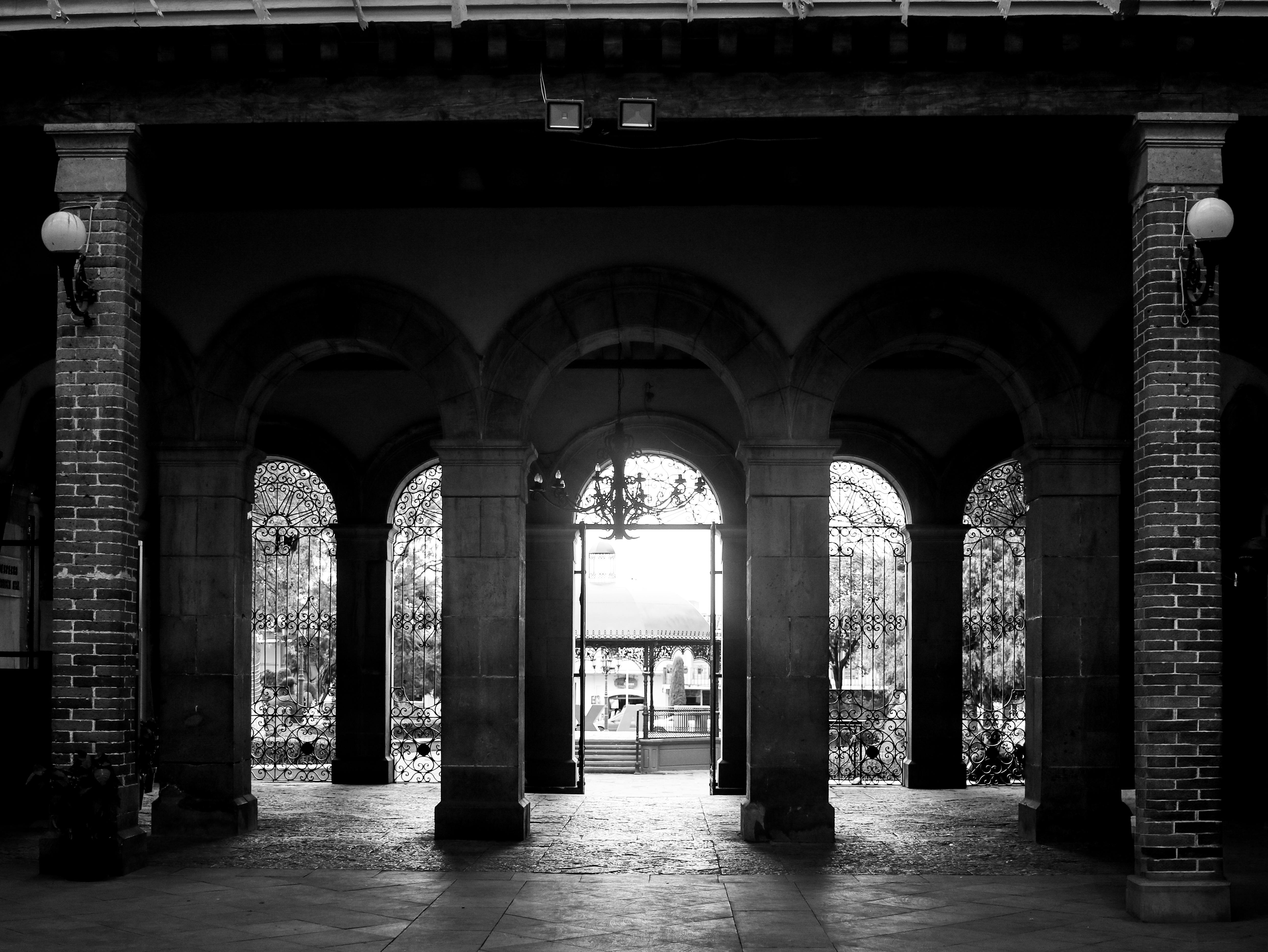 ฟรี ภาพถ่ายขาวดำอันโดดเด่นของทางเดินโค้งที่มีรายละเอียดสถาปัตยกรรมอันซับซ้อน คลังภาพถ่าย