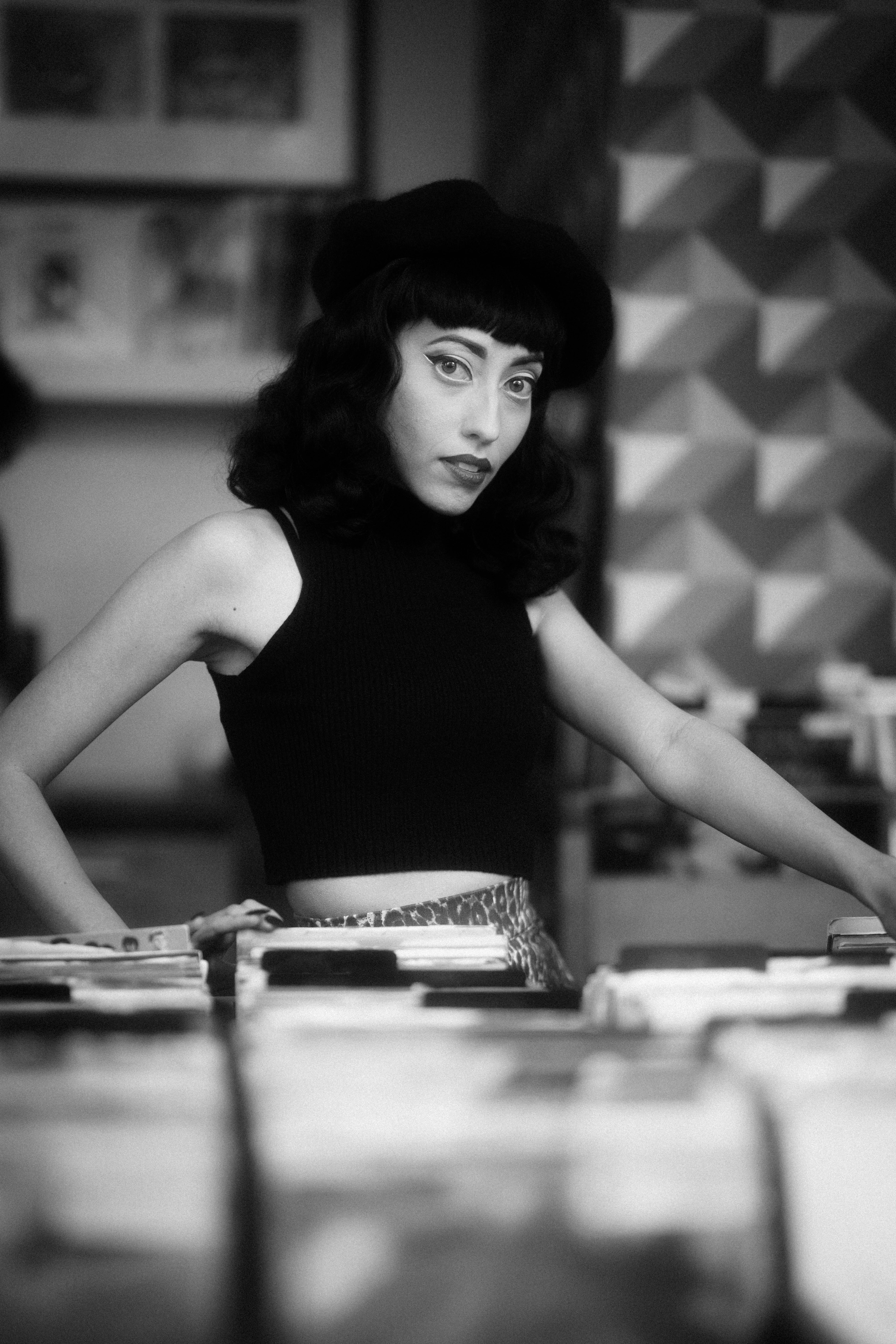 Gratis Retrato en blanco y negro de una mujer elegante con vibraciones vintage en una tienda de discos. Foto de stock