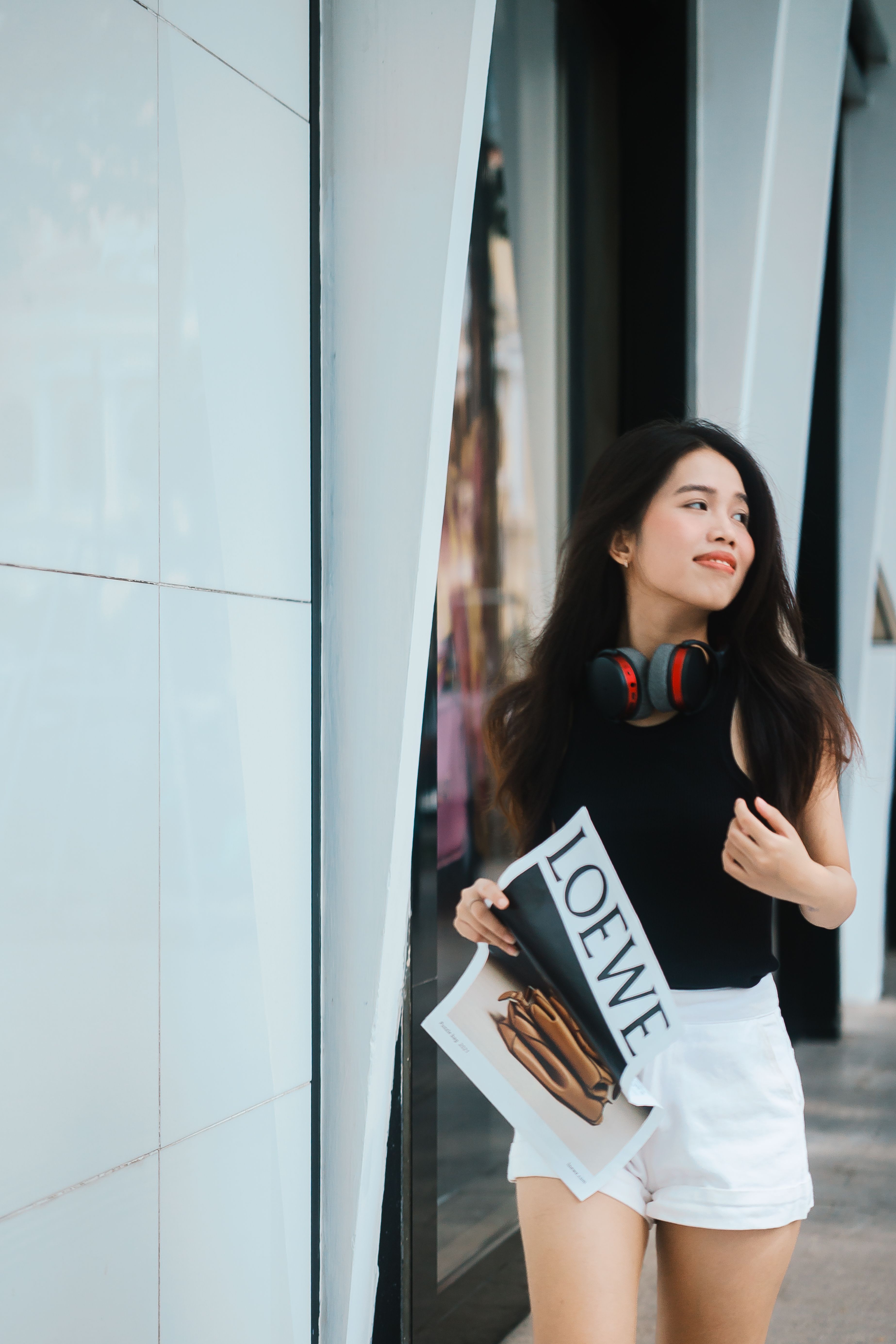 Young Woman with Headphones and Magazine Outdoors