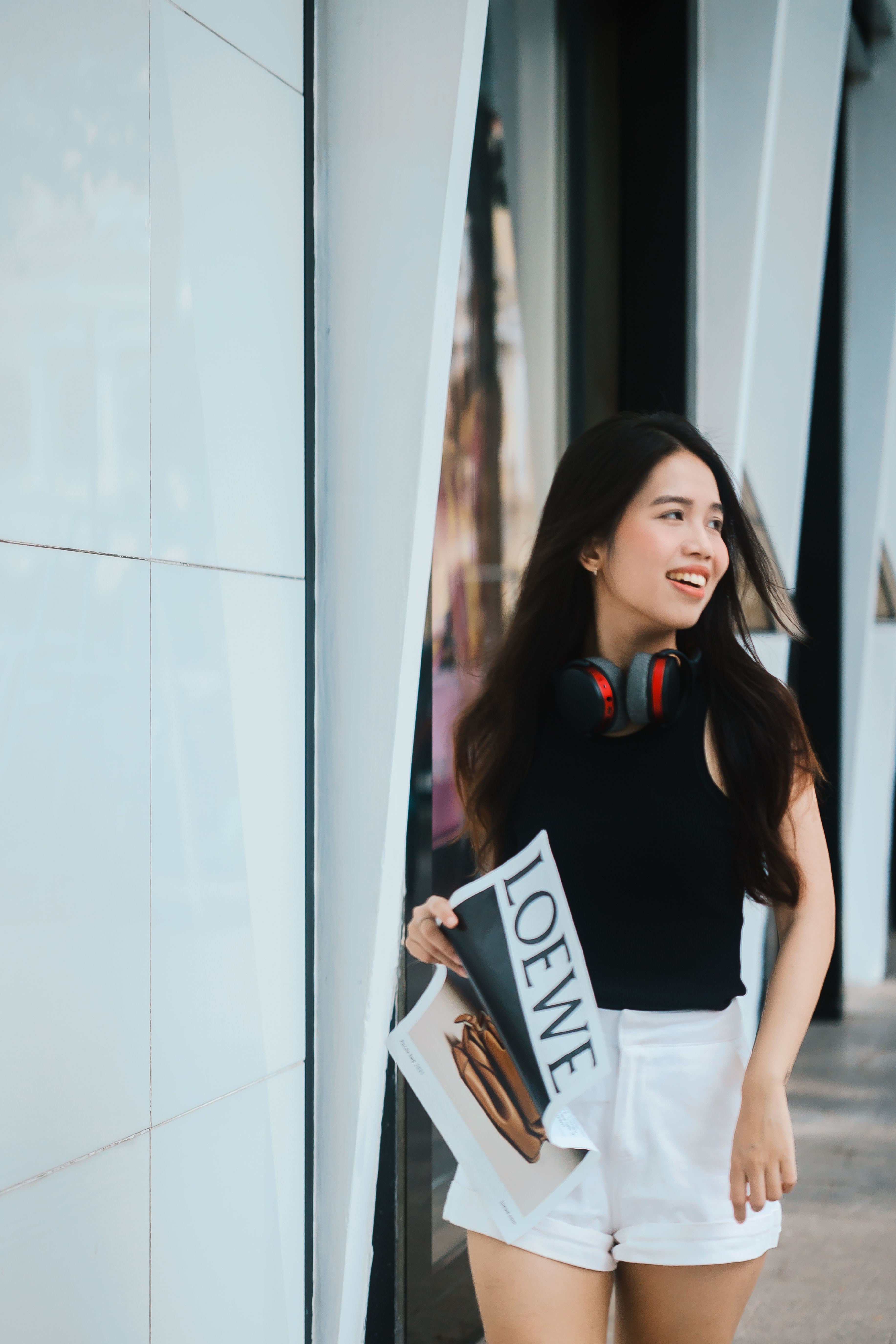 Young Woman Smiling with Headphones and Shopping Bag
