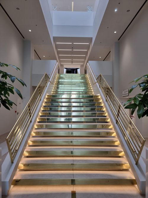 Free A modern staircase with elegant lighting and gold accents inside a spacious, minimalist building in Greece. Stock Photo