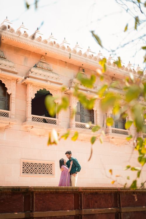 Free A loving couple embraces in front of a beautifully adorned ancient temple, capturing a moment of romance and cultural heritage. Stock Photo
