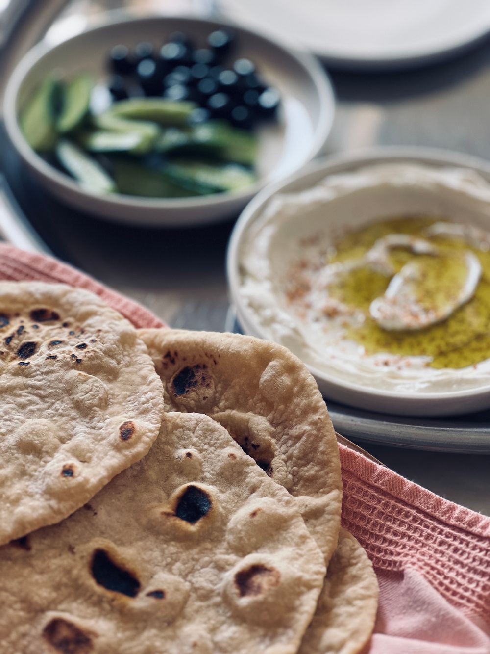 A spread of flatbreads, dips and olives ready for catering