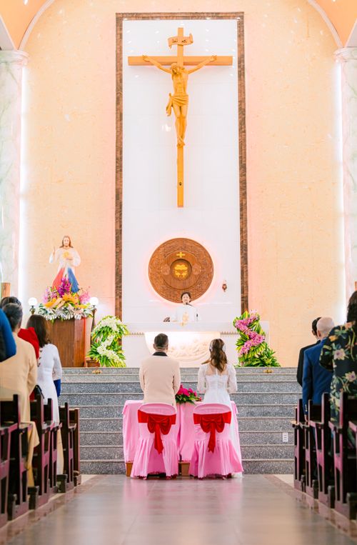 Free Bride and groom at the altar during a church wedding ceremony with floral decorations. Stock Photo
