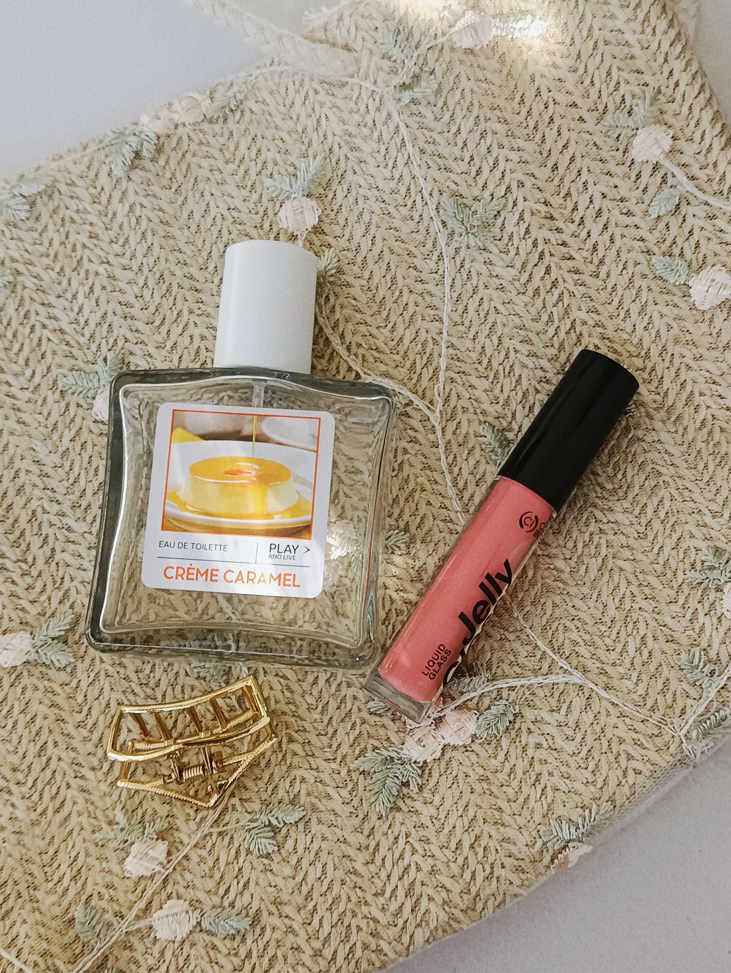 Flat lay collection de gloss Mouna Cosmetics sur fond terracotta chaud