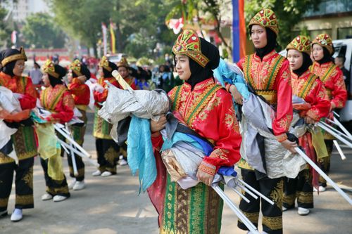 Free Women in vibrant traditional attire participate in an outdoor cultural parade, showcasing heritage and community spirit. Stock Photo