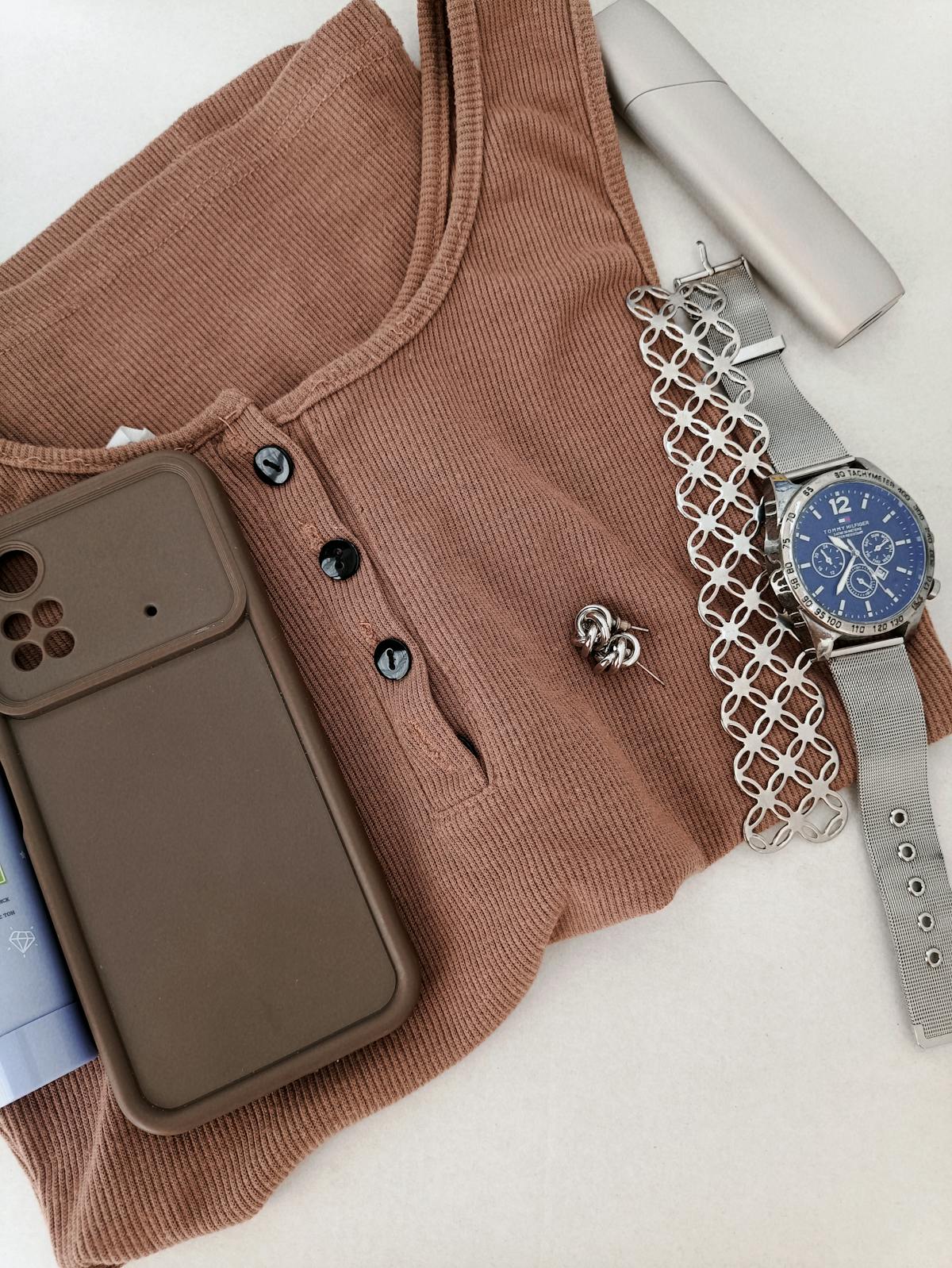Flat lay di capi e accessori disposti su superficie bianca