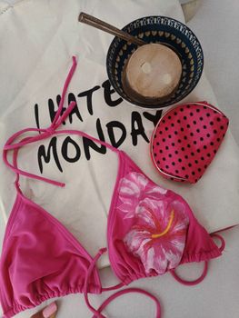 Flat lay of tropical accessories and bikini exuding summer beach vibes.