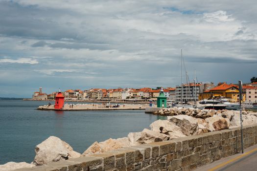 Explore the vibrant coastline of Piran with its distinctive red lighthouse and charming architecture.