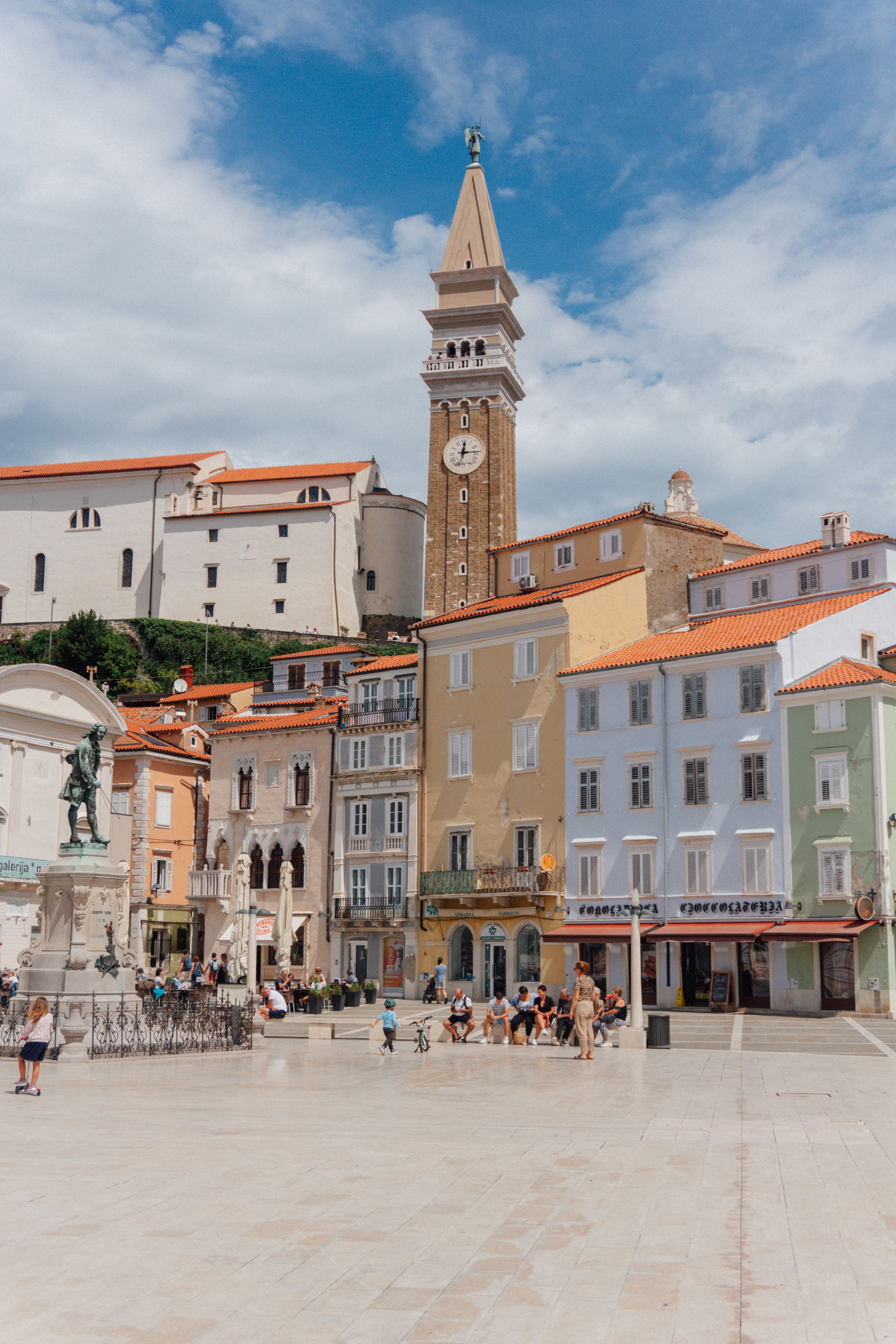 Charming view of Tartini Square with colorful architecture and the iconic clock tower in Piran, Slovenia.