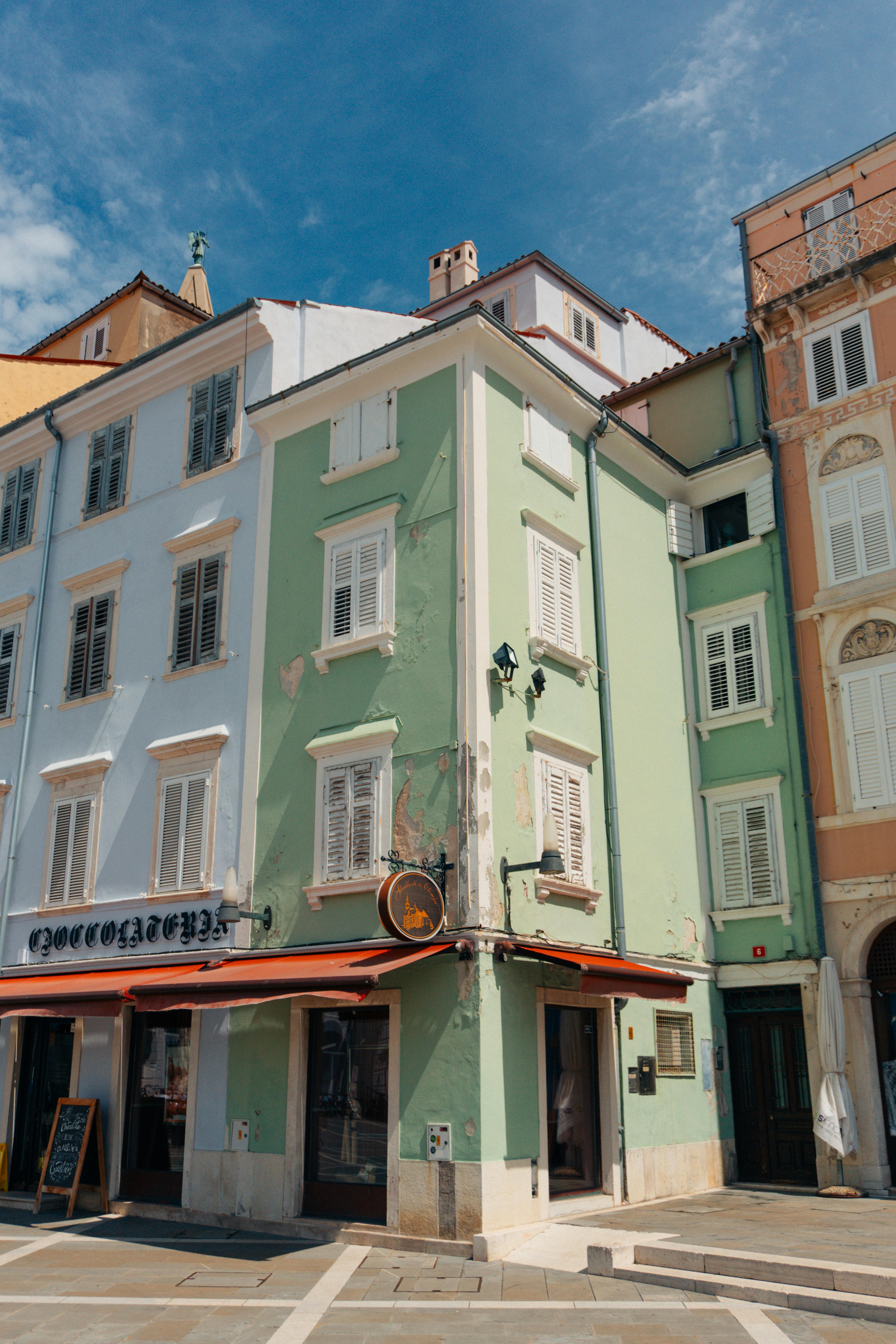 Picturesque view of colorful historic buildings in Piran, Slovenia under a sunny sky.