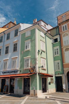 Picturesque view of colorful historic buildings in Piran, Slovenia under a sunny sky.