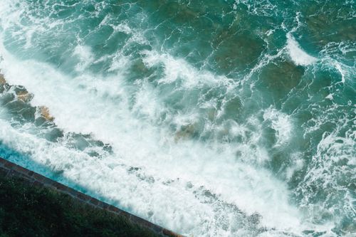 Free Beautiful aerial view of turquoise sea waves crashing on the rocky shore of Piran, Slovenia. Stock Photo