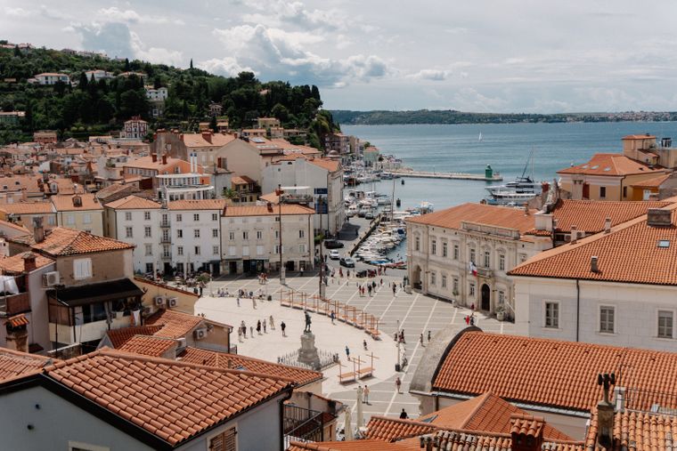 A harbour square ringed by terracotta rooftops above a small marina — photo by Raymond Petrik on Pexels