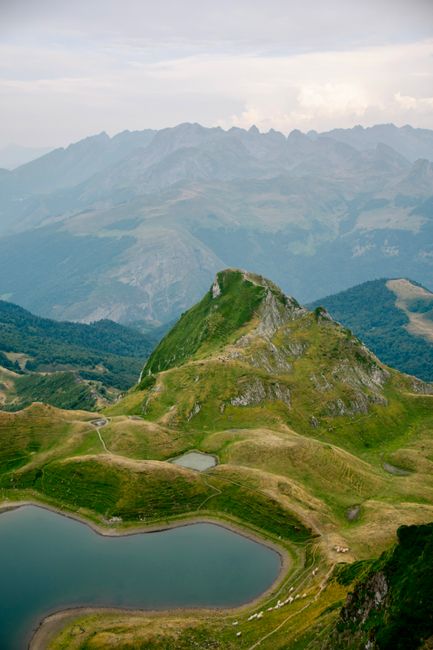 Stunning aerial view of the Pyrenees mountains with lush greenery and tranquil lakes in Nouvelle-Aquitaine, France.