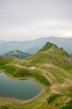 A tranquil mountain scene with a serene lake amid rolling hills, perfect for nature lovers.