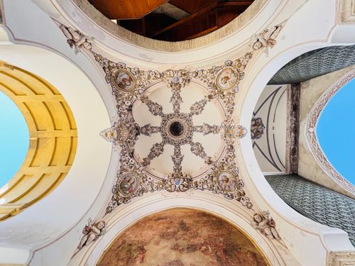 Free Captivating view of a Spanish architectural ceiling with ornate details and a bright sky backdrop. Stock Photo