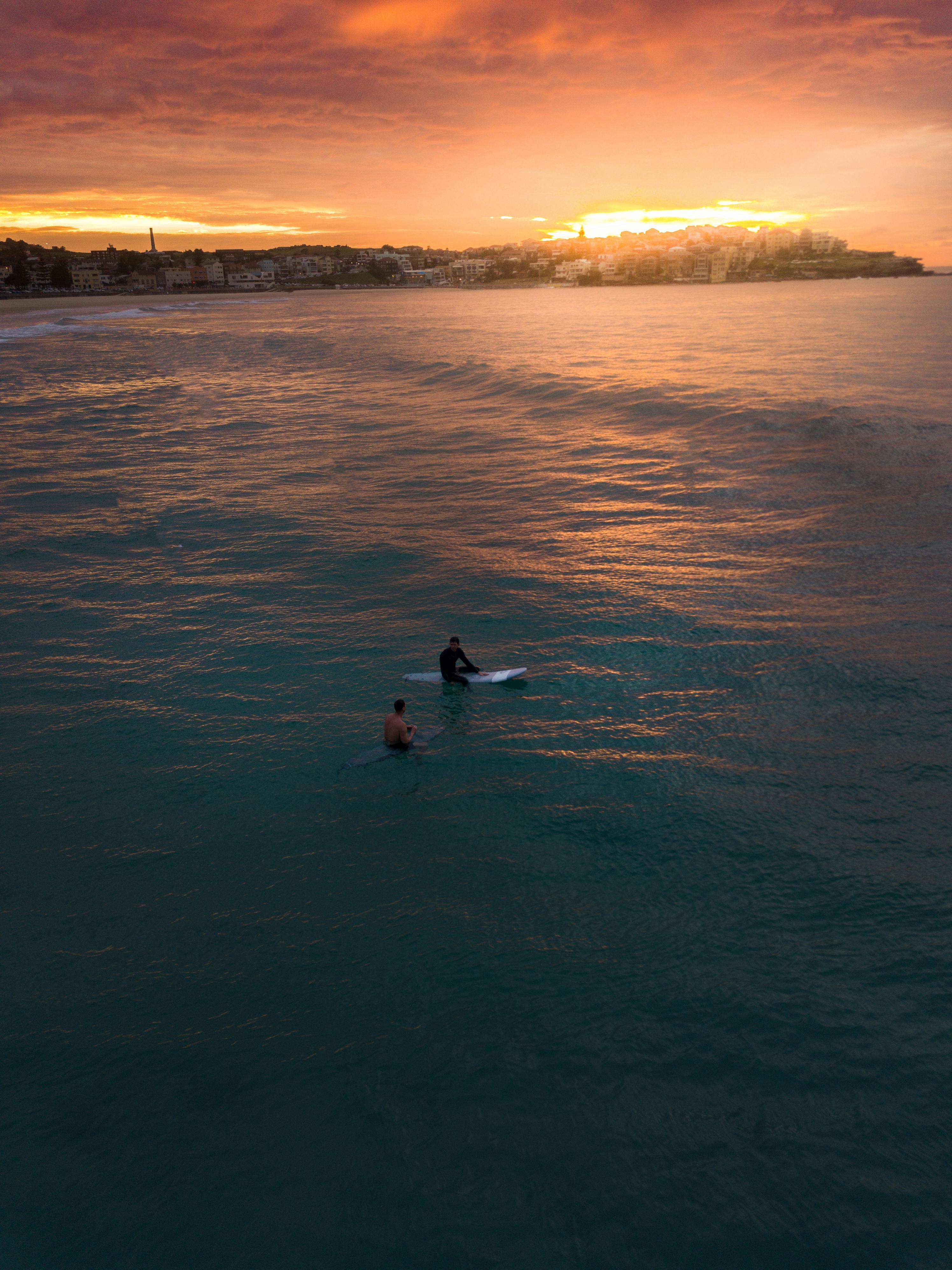 photo of two people surfing in bondi beach