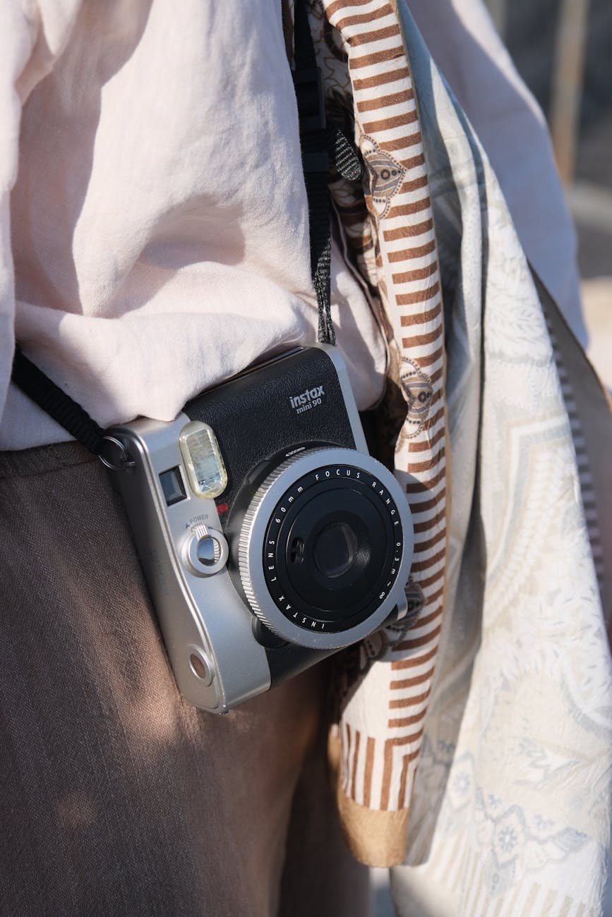 A stylish vintage camera worn against a casual outfit, perfect for capturing moments.