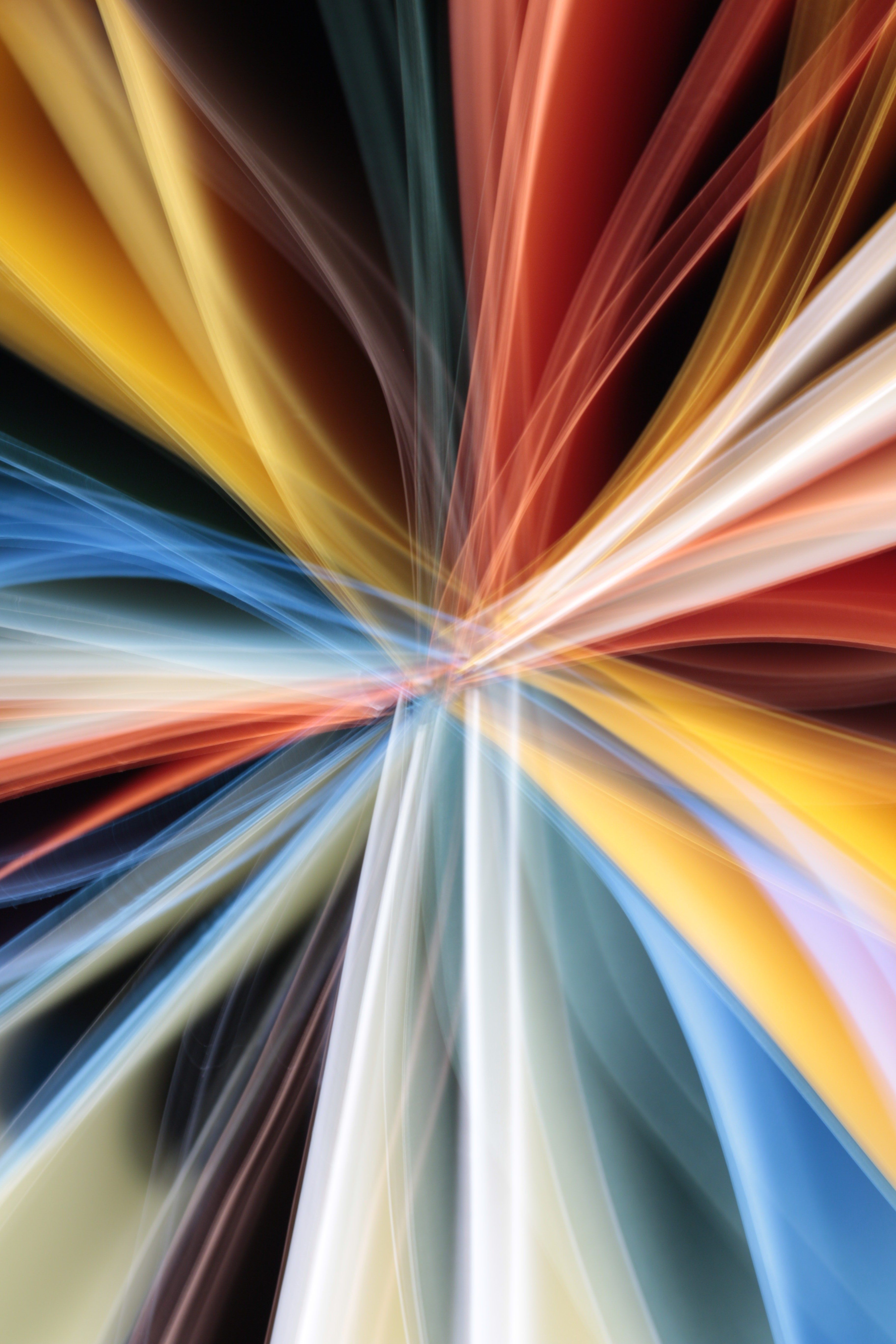 Abstract photo of colorful light streaks creating a dynamic pattern on a dark background.