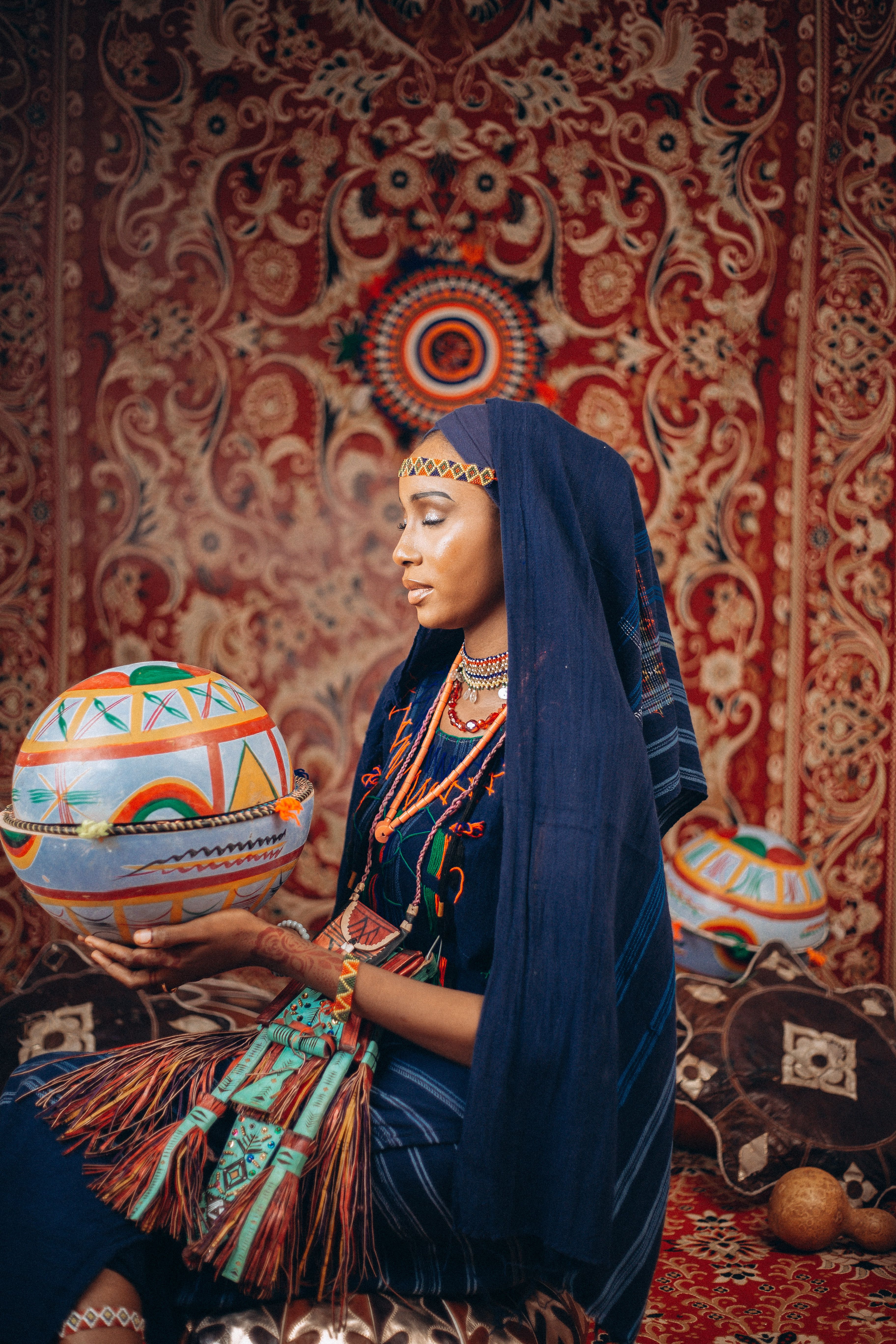 Elegant Woman in Traditional African Garb Holding Decorated Sphere ...