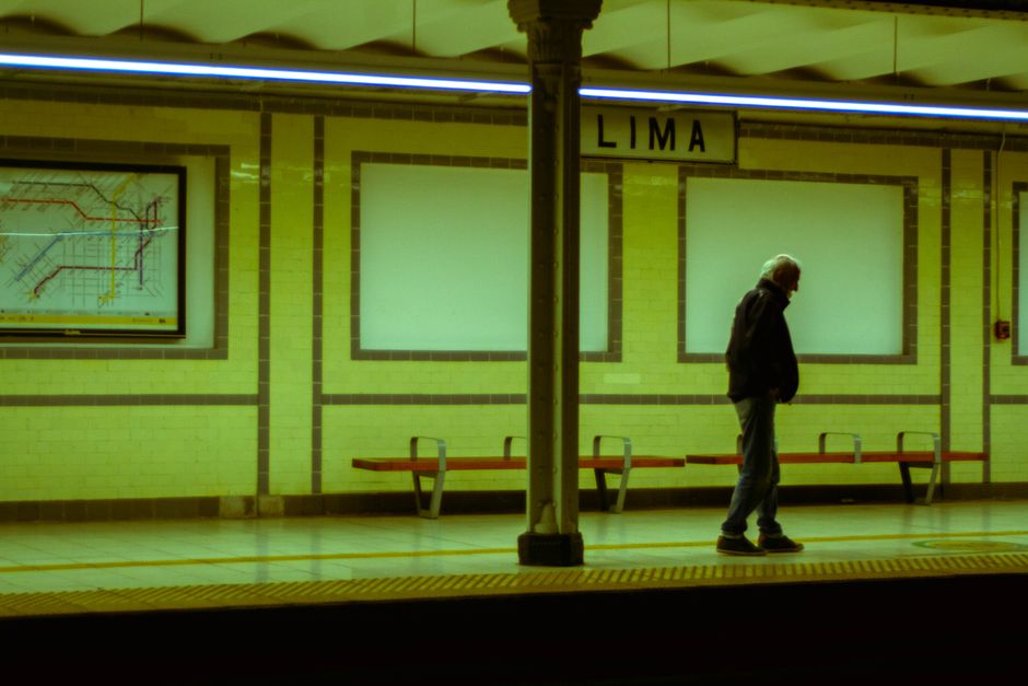 Fotomural Hombre de pie en la estación de metro de Lima en Buenos Aires por la noche, mostrando la soledad urbana.