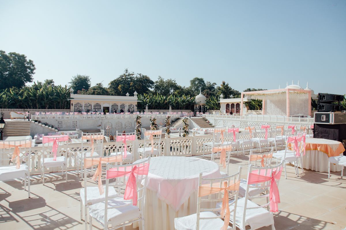 Elegant outdoor wedding venue with floral arch and reception chairs