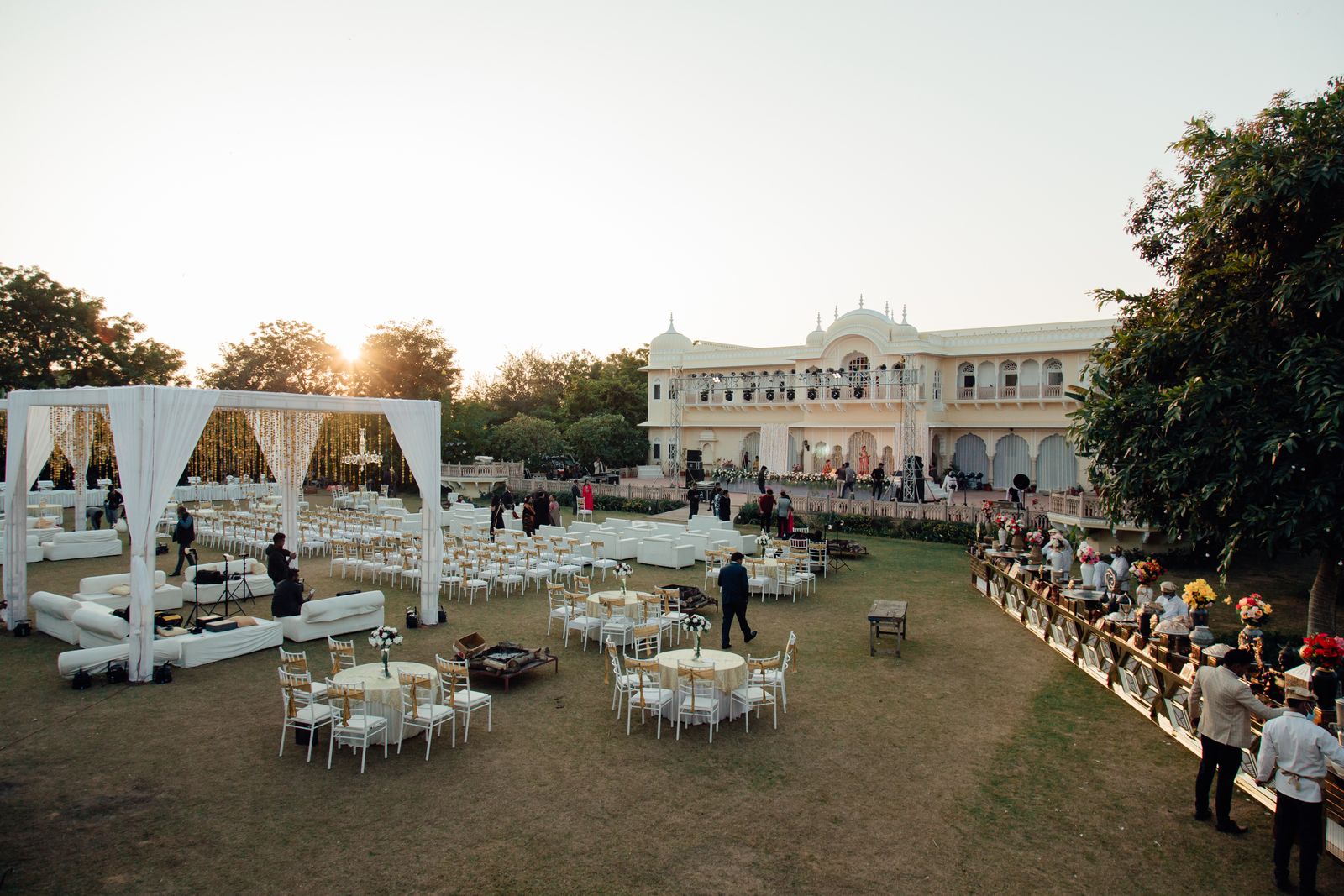 An outdoor wedding reception with long tables in a garden