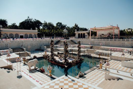 Beautifully decorated outdoor wedding venue with floral arrangements and poolside setup.