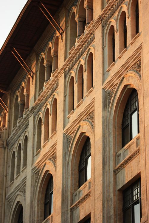 Free Ornate arched windows of a historic İstanbul building illuminated by sunset light. Stock Photo