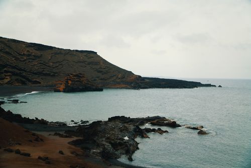 Free Scenic view of Lanzarote's rugged coastline and blue ocean under a cloudy sky. Stock Photo