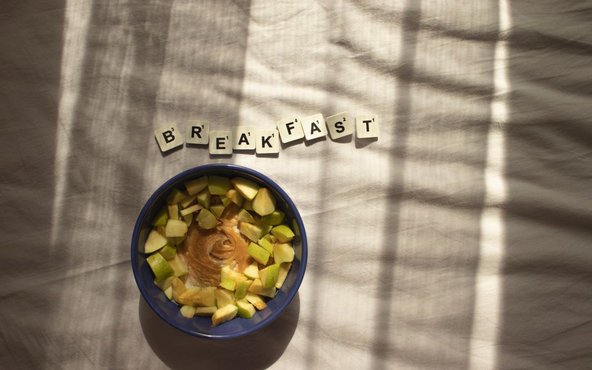 A nutritious breakfast bowl with peanut butter and apples in natural lighting.