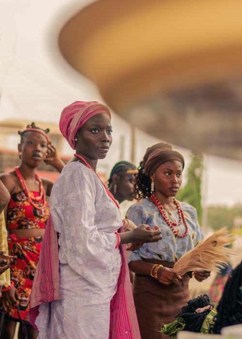 Free Women in traditional attire celebrate during a cultural ceremony outdoors. Stock Photo