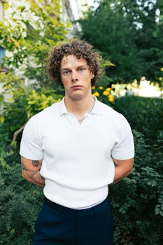 Young man with curly hair posing outdoors in Berlin, Germany.