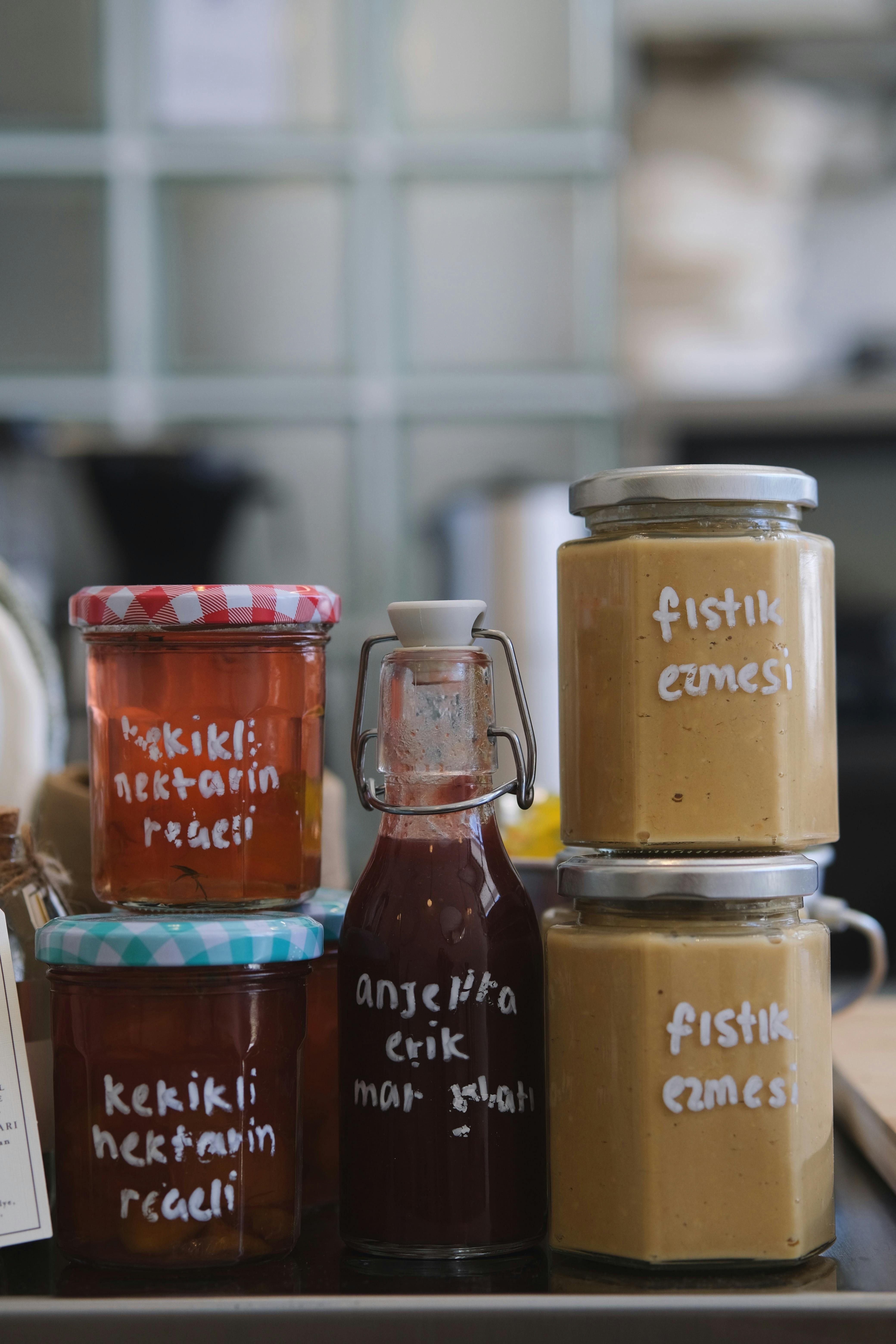 Assorted homemade jams and spreads in jars, labeled with flavors.